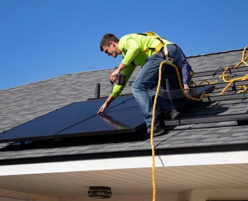 roof inspector examining shingles on residential home in Oregon - how regular inspections catch problems early