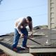 Professional roofing contractor examining shingles on a Pacific Northwest home - roof inspection frequency for pacific