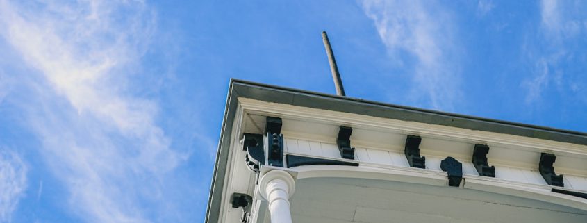 clean seamless gutters on a home with lush green Pacific Northwest landscaping - how gutter maintenance prevents foundation