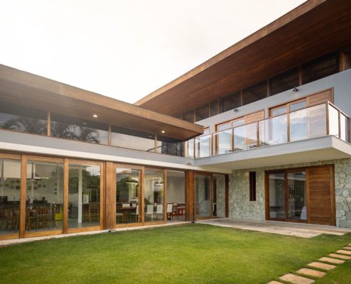 gutter systems on a modern home with water flowing through downspouts - gutter systems and why they matter for your roof