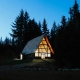 Pacific Northwest home with rain falling on roof surrounded by tall evergreen trees